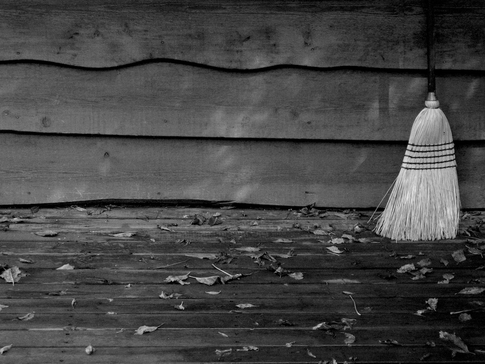 An old broom by the side of an old house