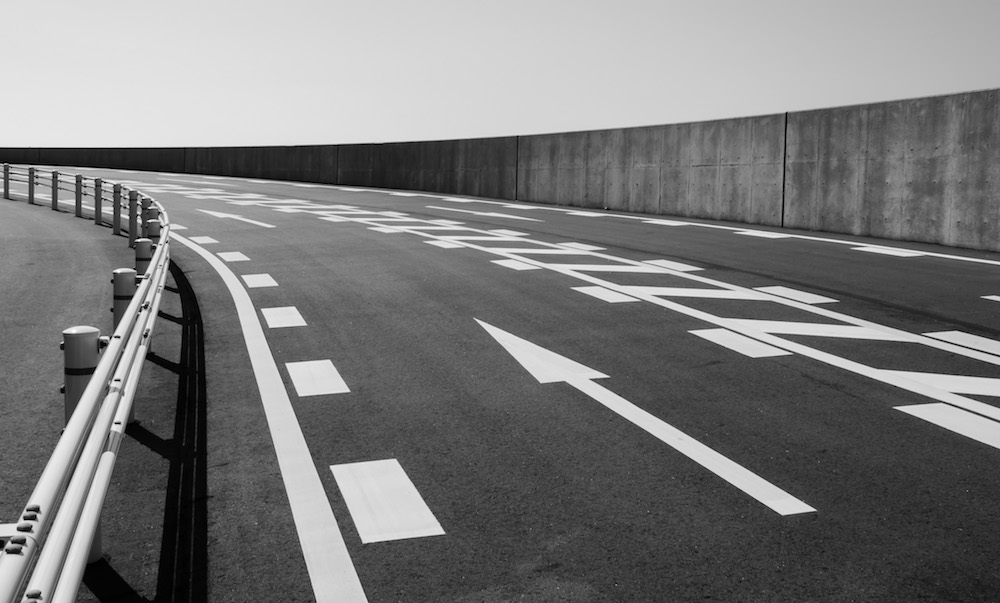 Concrete road with arrow symbol on mountain in monochrome style